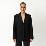 Person wearing Ninepine black blazer on a white background