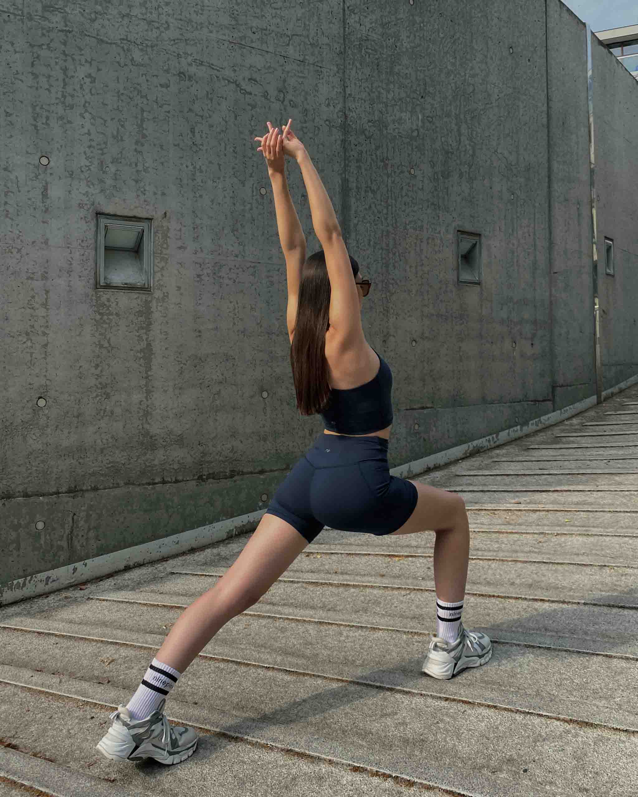 Girl in ninepine set stretching on concrete ramp